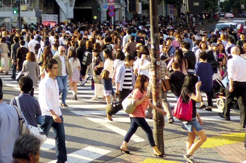 Many people walking and crossing the street in busy city center